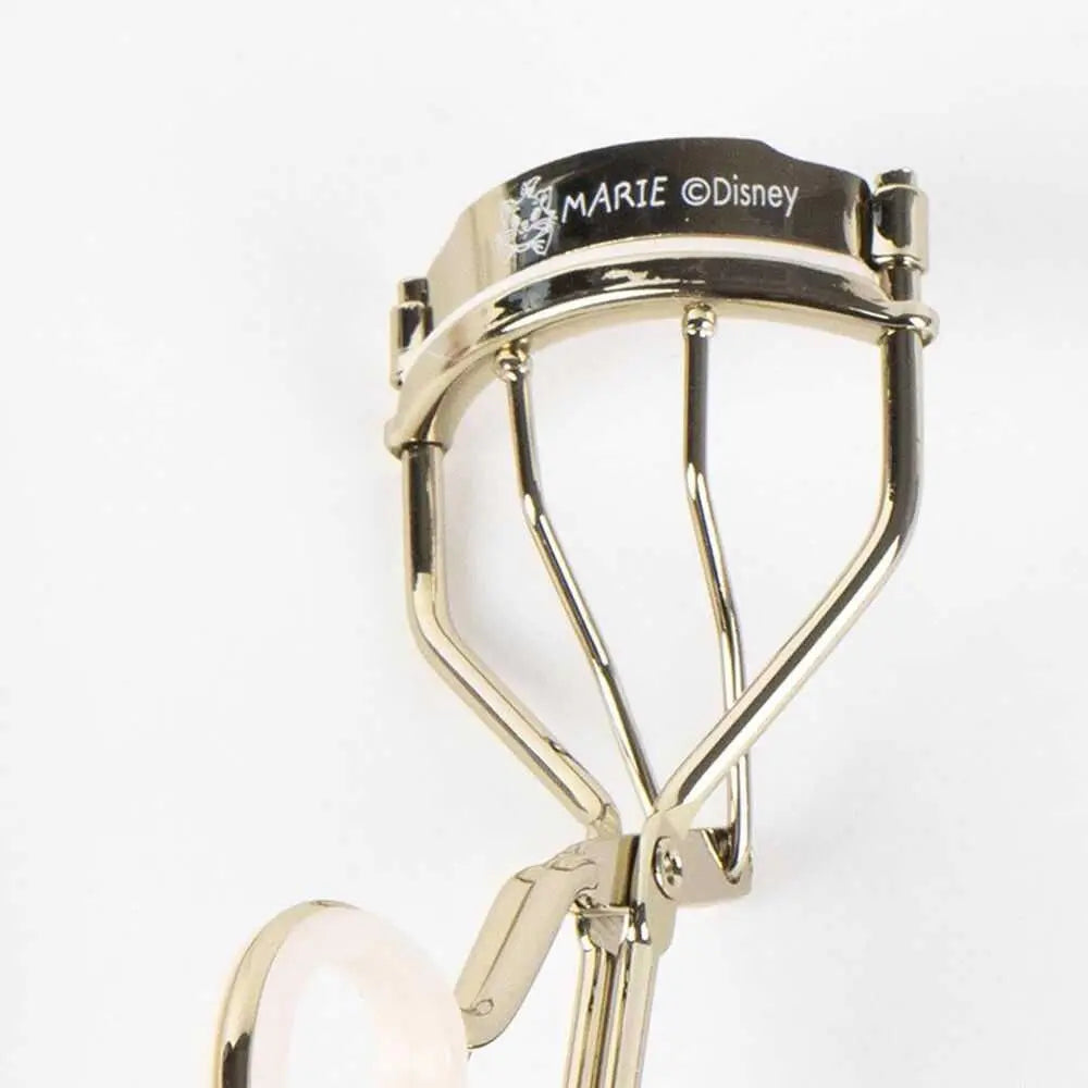 Piega ciglia dorato Marie Disney su sfondo bianco, accessorio make up Nerdscape