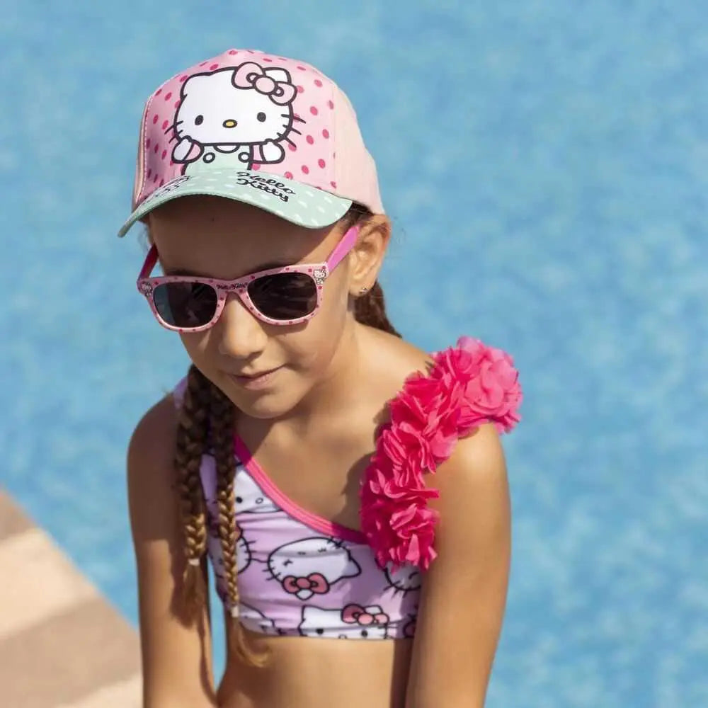 Bambina con cappellino, occhiali e costume Hello Kitty rosa a bordo piscina, Nerdscape moda estiva