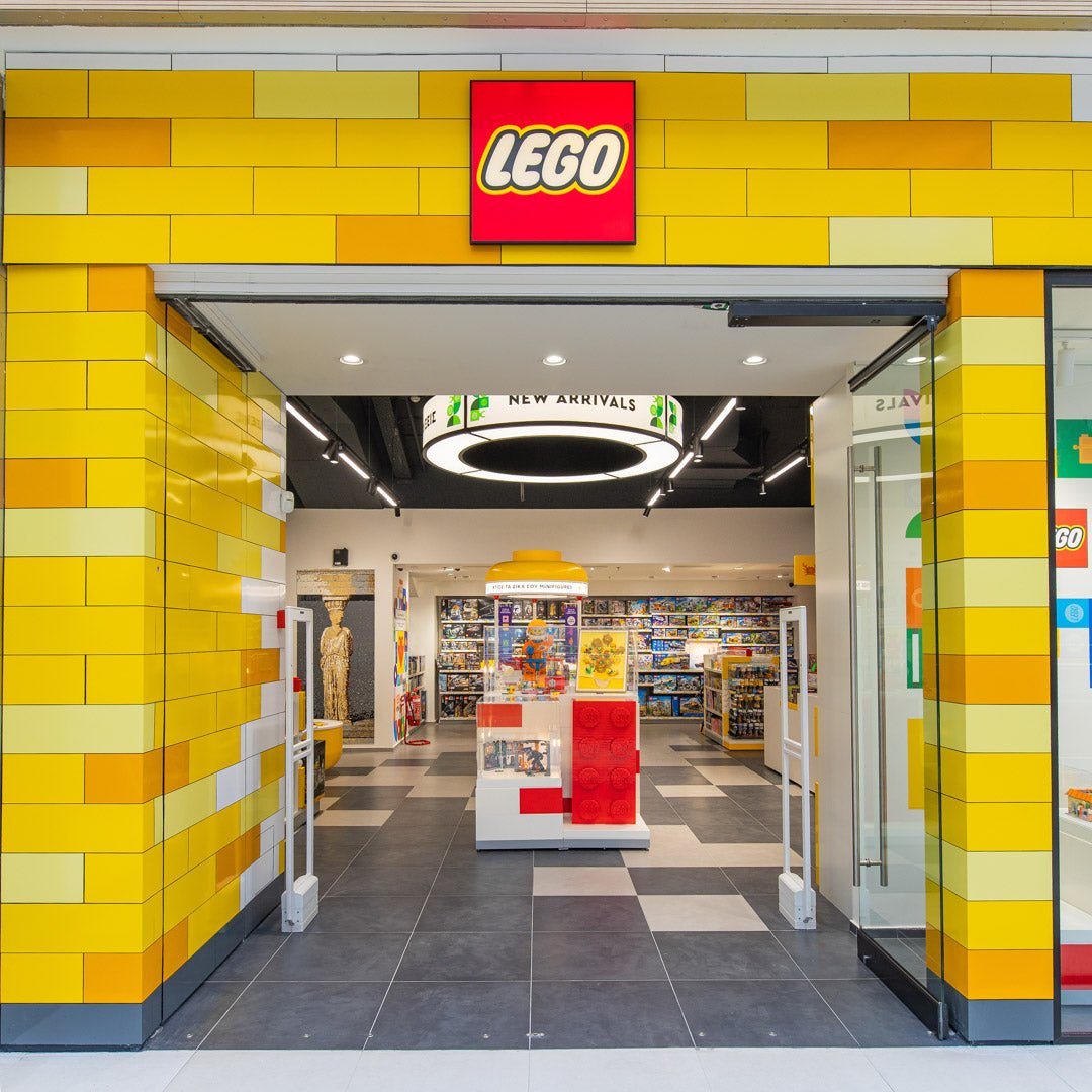 Ingresso del LEGO Store colorato di giallo, con esposizione di set e logo LEGO, ideale per Nerdscape.