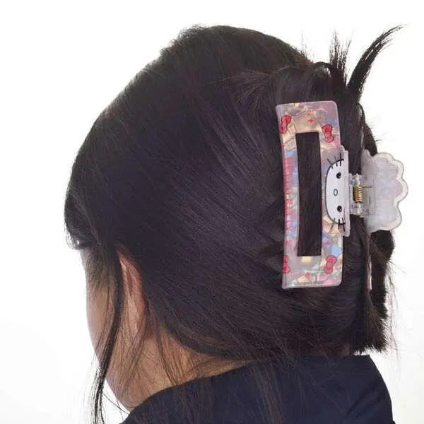 Fermaglio per capelli Hello Kitty colorato su capelli castani, accessorio Nerdscape.