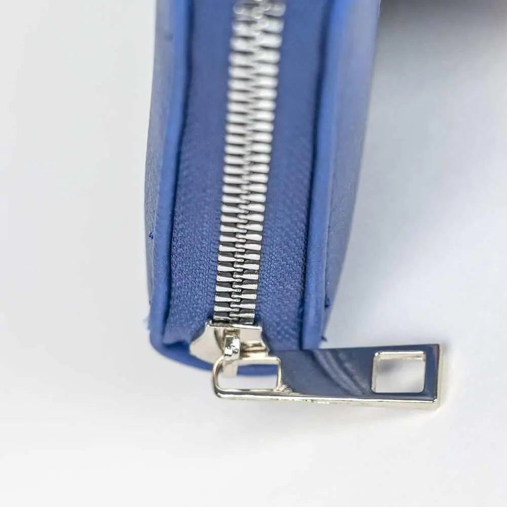Dettaglio chiusura lampo metallica su astuccio blu, accessorio Nerdscape