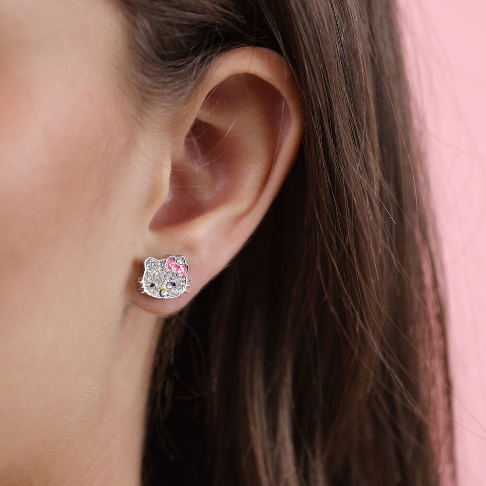 Orecchino a lobo Nerdscape placcato argento con faccina glitterata e fiocco rosa, indossato su donna