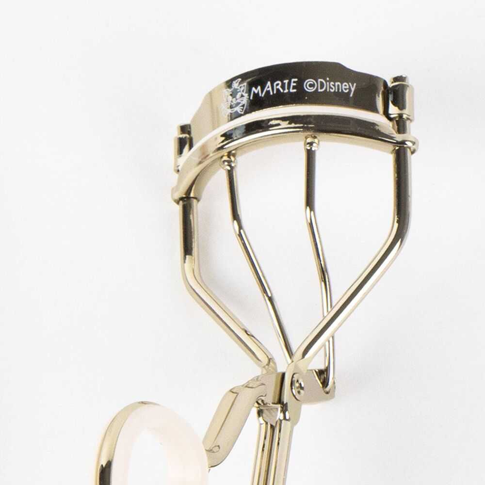 Piega ciglia dorato Marie Disney su sfondo bianco, accessorio make up Nerdscape